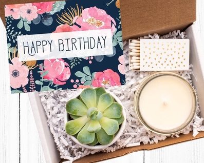 box with happy birthday card, candle, succulent, candle, matches, and confetti