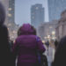 Selective Focus Photograph of Person Wearing Purple Hoodie Jacket Walking on Street Responding to Environment